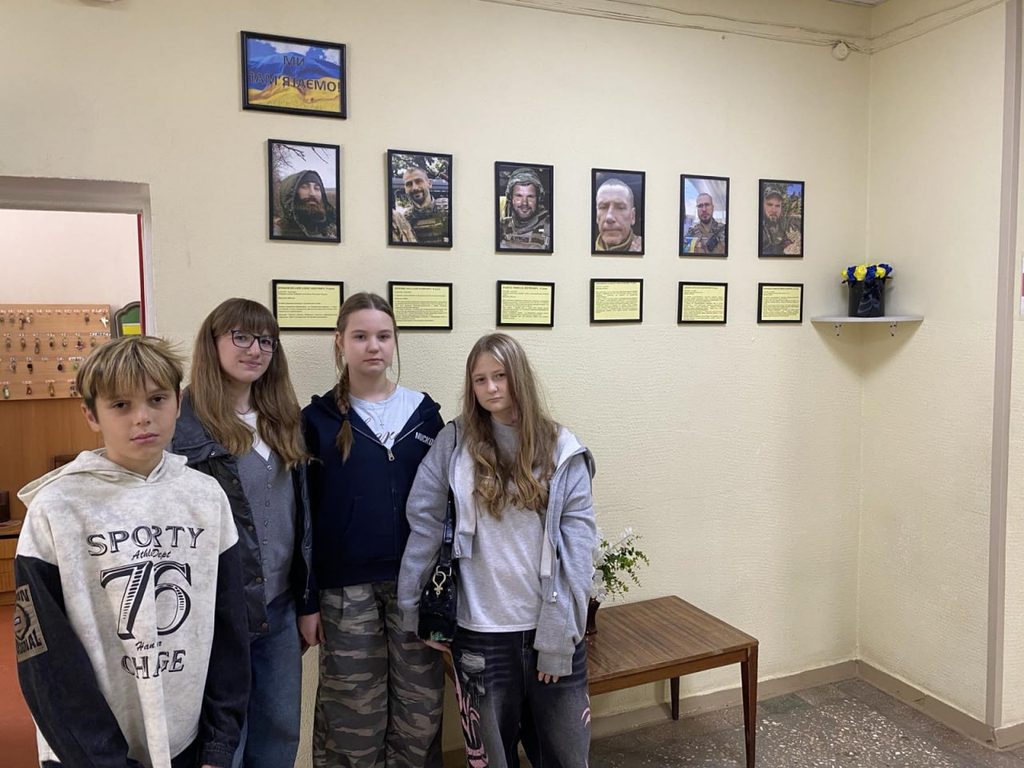 Фотографія учнів у Куточку пам'яті випускників нашої школи